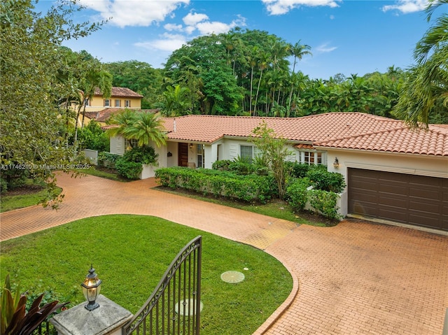 view of front of house with decorative driveway, stucco siding, an attached garage, a tiled roof, and a front lawn