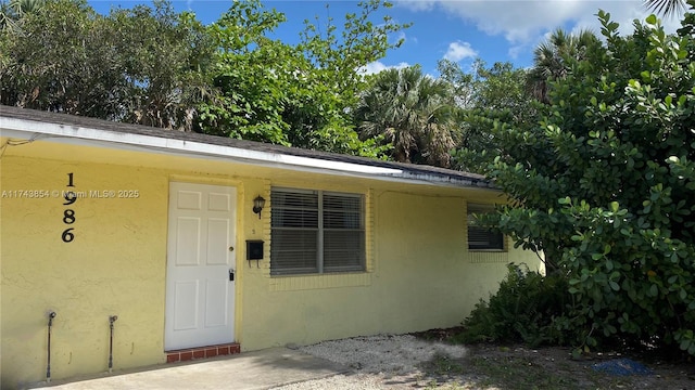 view of exterior entry featuring stucco siding