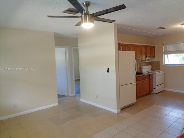 kitchen with brown cabinets, white appliances, visible vents, and a textured ceiling