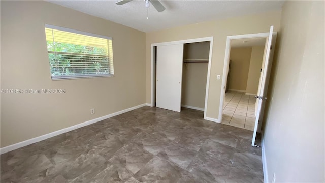 unfurnished bedroom featuring ceiling fan, a closet, a textured ceiling, and baseboards