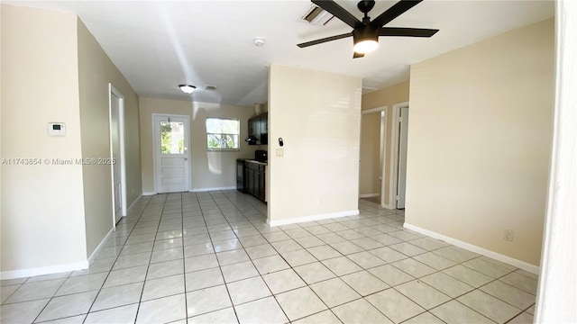 spare room with ceiling fan, light tile patterned flooring, and baseboards