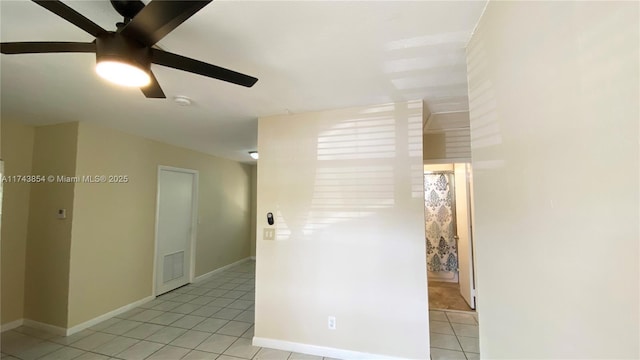 spare room with light tile patterned floors, ceiling fan, visible vents, and baseboards