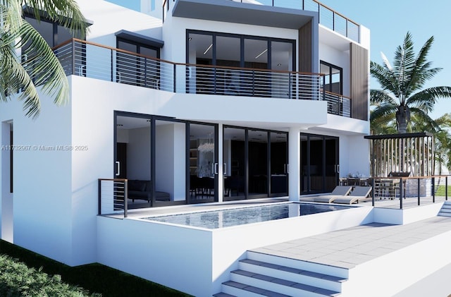 rear view of house featuring a patio area, an outdoor pool, and stucco siding