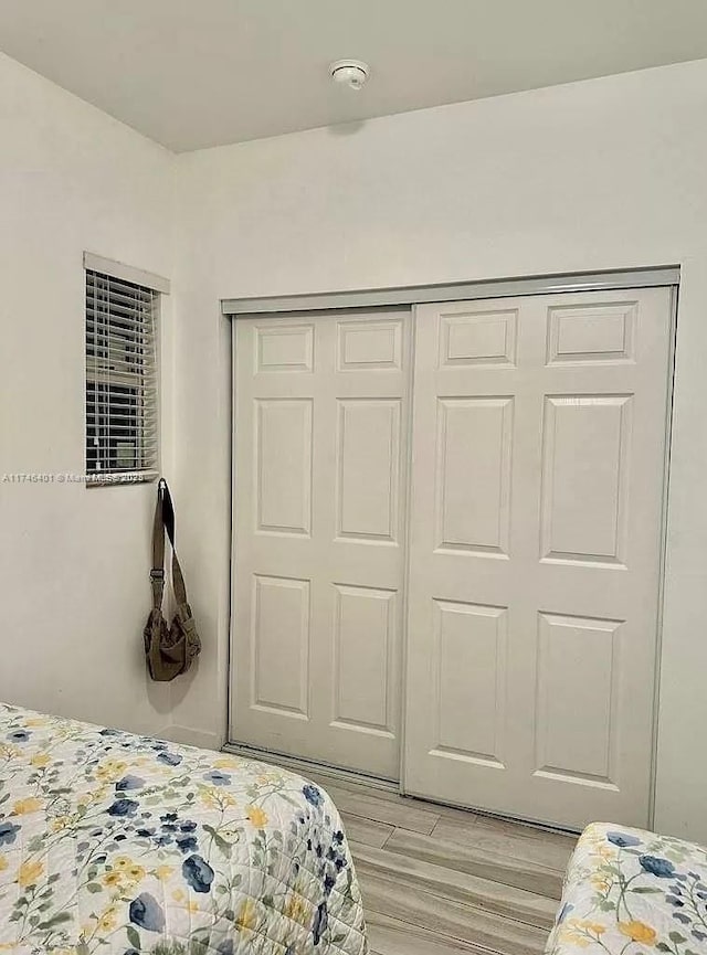 bedroom featuring light wood-type flooring and a closet