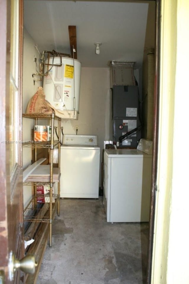 washroom featuring heating unit, water heater, and washing machine and clothes dryer