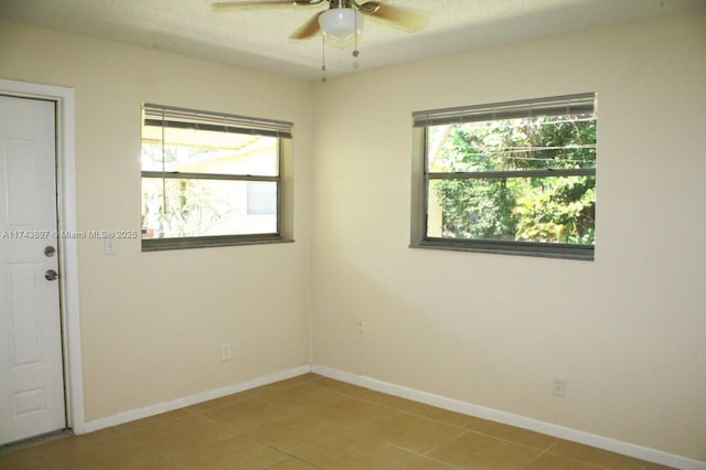 spare room with tile patterned flooring, a textured ceiling, and ceiling fan