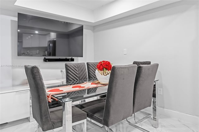 dining space featuring marble finish floor and baseboards