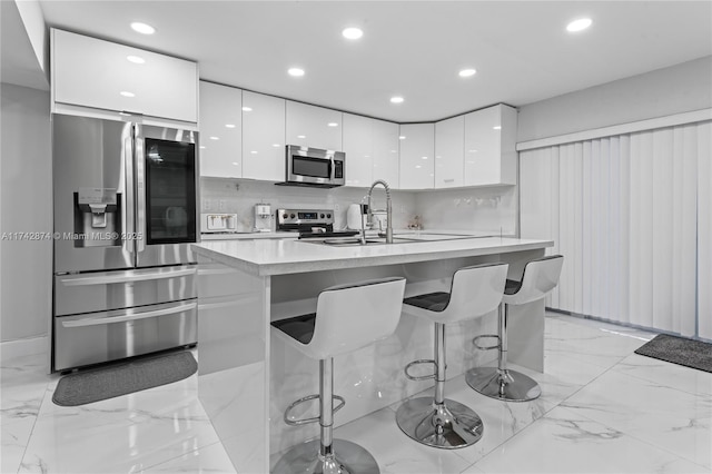 kitchen featuring white cabinets, a breakfast bar, and stainless steel appliances