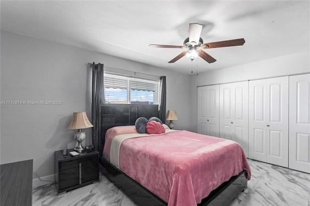 bedroom featuring a closet, marble finish floor, ceiling fan, and baseboards