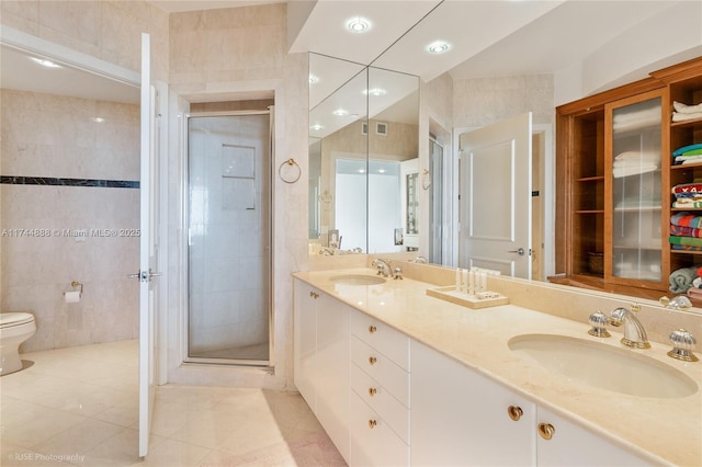 bathroom featuring walk in shower, tile patterned floors, toilet, tile walls, and vanity