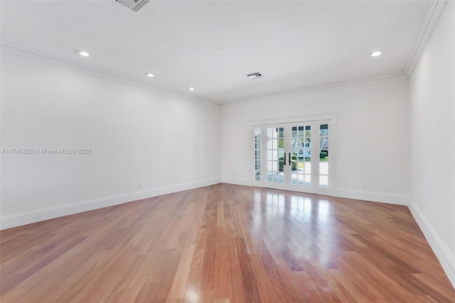 spare room featuring crown molding, light hardwood / wood-style floors, and french doors