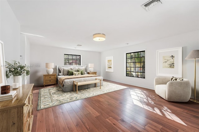 bedroom featuring multiple windows and dark wood-type flooring