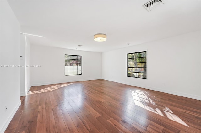 empty room with plenty of natural light and wood-type flooring