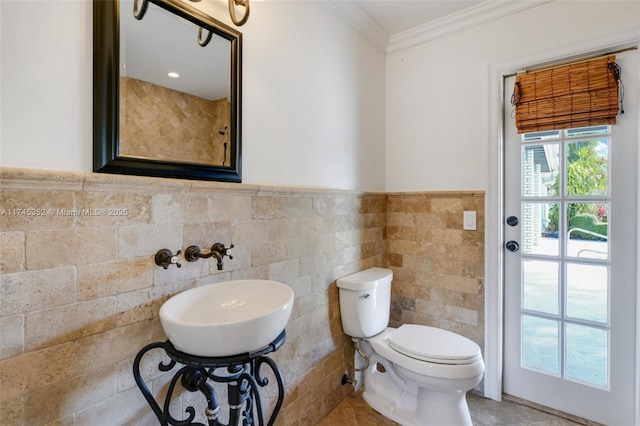 bathroom with ornamental molding, sink, tile walls, and toilet