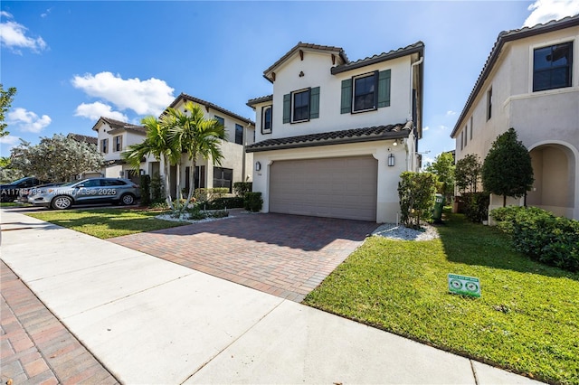 mediterranean / spanish home featuring a front yard and a garage