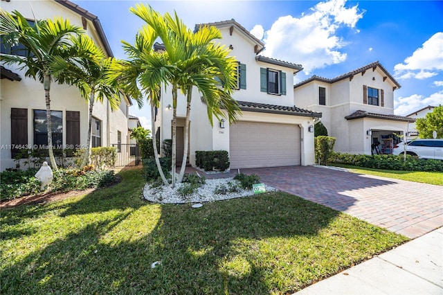 mediterranean / spanish-style home featuring a front lawn and a garage