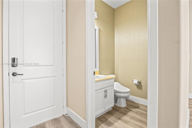 bathroom with wood-type flooring, vanity, and toilet