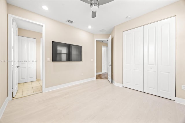 unfurnished bedroom with ceiling fan, a closet, and light hardwood / wood-style floors