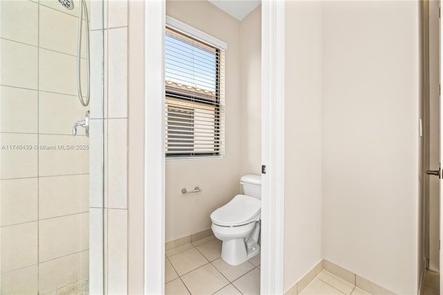 bathroom with tile patterned floors, tiled shower, and toilet