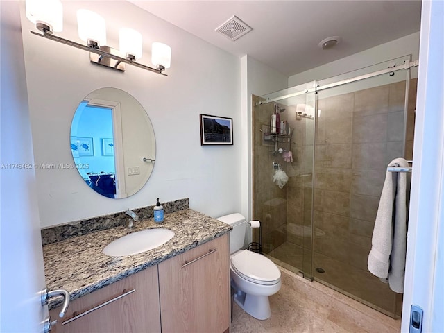 bathroom with visible vents, a shower stall, toilet, and vanity