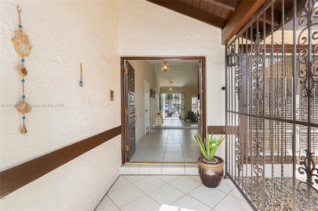 hall featuring tile patterned flooring and lofted ceiling