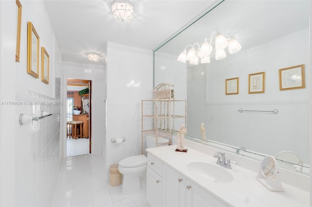 bathroom with vanity, toilet, tile patterned flooring, and tile walls