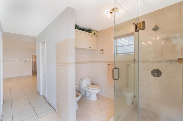 bathroom featuring tile patterned floors, toilet, a shower with shower door, tile walls, and a bidet