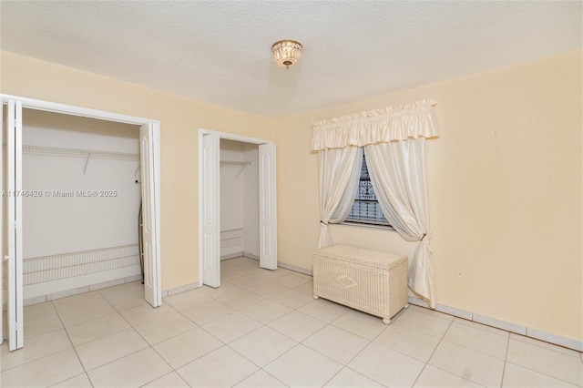 unfurnished bedroom featuring light tile patterned floors and a textured ceiling