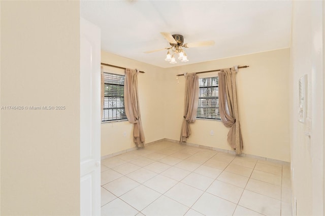 tiled empty room featuring a healthy amount of sunlight and ceiling fan