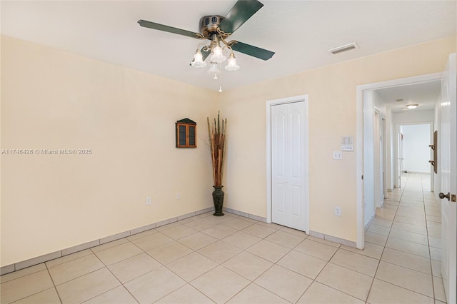 empty room with ceiling fan and light tile patterned flooring