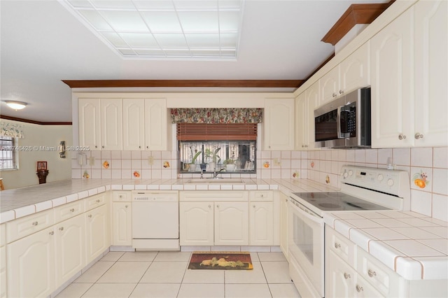 kitchen featuring light tile patterned flooring, white appliances, tile countertops, and kitchen peninsula