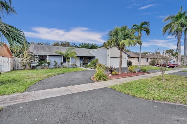 single story home featuring a garage and a front yard