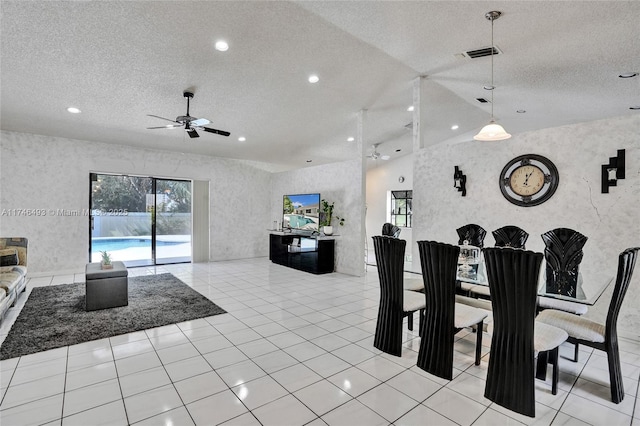 tiled dining space with ceiling fan, vaulted ceiling, and a textured ceiling