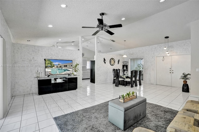 tiled living room featuring a textured ceiling, vaulted ceiling, and ceiling fan