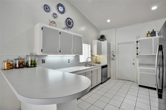 kitchen with appliances with stainless steel finishes, sink, light tile patterned floors, and kitchen peninsula