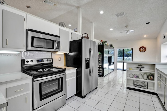 kitchen featuring light tile patterned flooring, white cabinets, backsplash, stainless steel appliances, and a textured ceiling