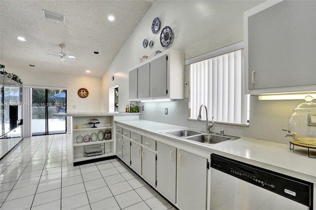 kitchen featuring sink, white cabinets, stainless steel dishwasher, light tile patterned floors, and kitchen peninsula