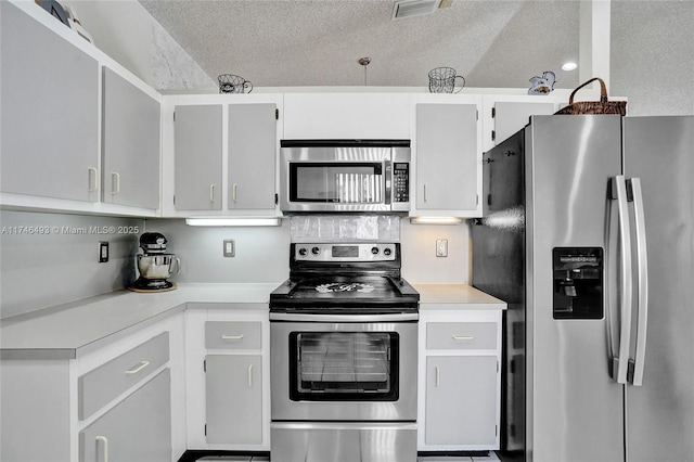 kitchen featuring white cabinetry, appliances with stainless steel finishes, and a textured ceiling