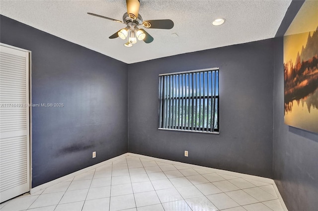 spare room featuring a textured ceiling and ceiling fan