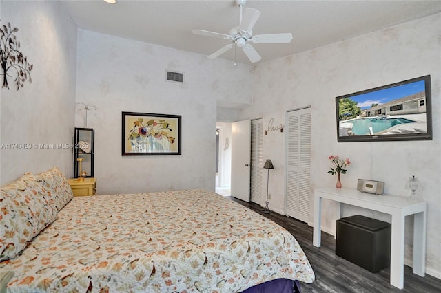 bedroom featuring dark hardwood / wood-style flooring, two closets, and ceiling fan