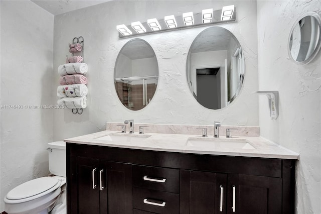 bathroom with vanity, toilet, and a shower with shower door