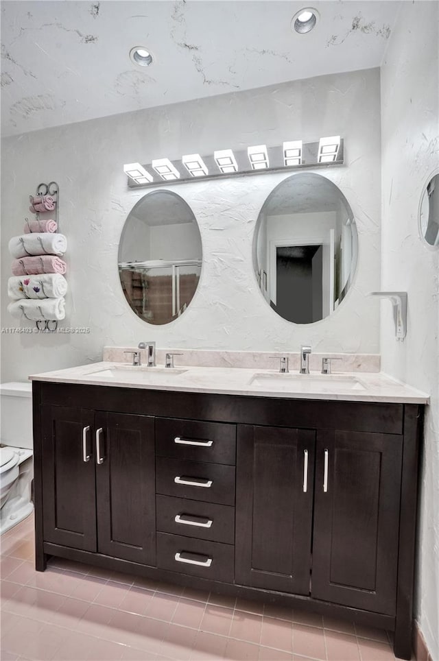 bathroom featuring vanity, toilet, and a shower with door