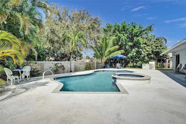 view of pool featuring an in ground hot tub, exterior kitchen, and a patio