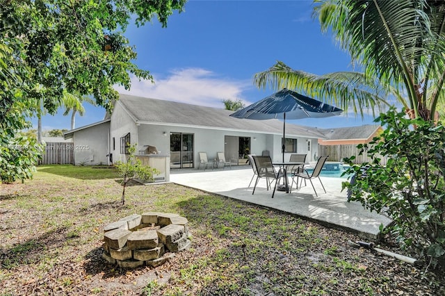 rear view of house with a fire pit and a patio