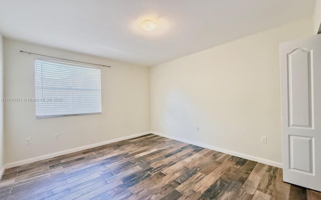 unfurnished room with dark hardwood / wood-style floors