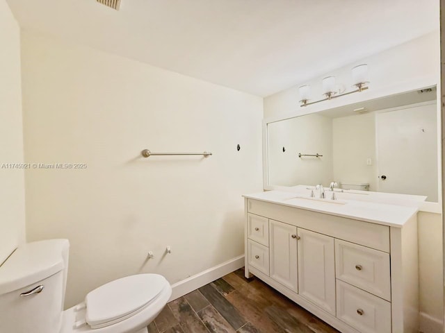 bathroom with hardwood / wood-style flooring, vanity, and toilet