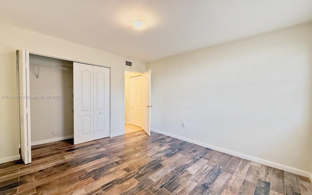 unfurnished bedroom featuring dark wood-type flooring and a closet