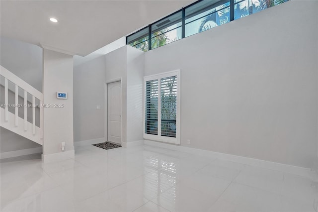 entrance foyer with light tile patterned flooring and a towering ceiling