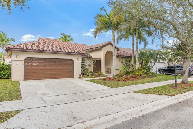 mediterranean / spanish house featuring a tile roof, driveway, an attached garage, and stucco siding