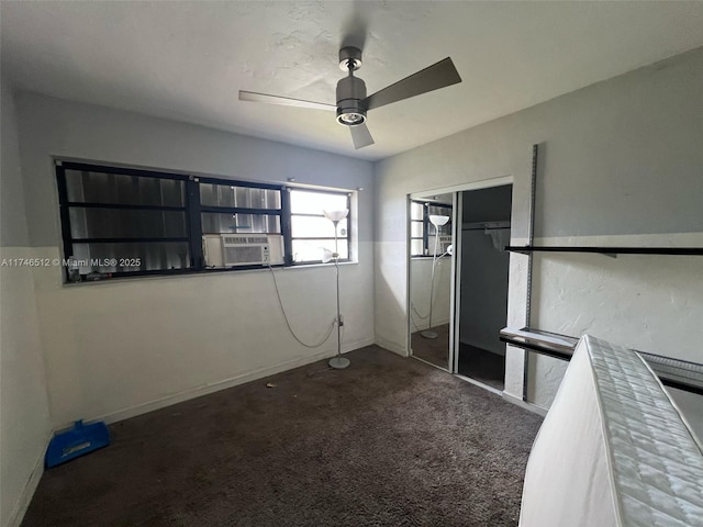 unfurnished bedroom featuring dark carpet, cooling unit, and ceiling fan